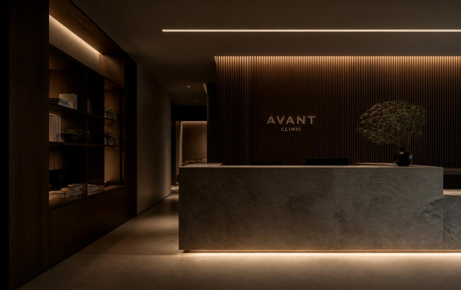 Dark, minimal clinic reception with stone counter and warm linear lighting